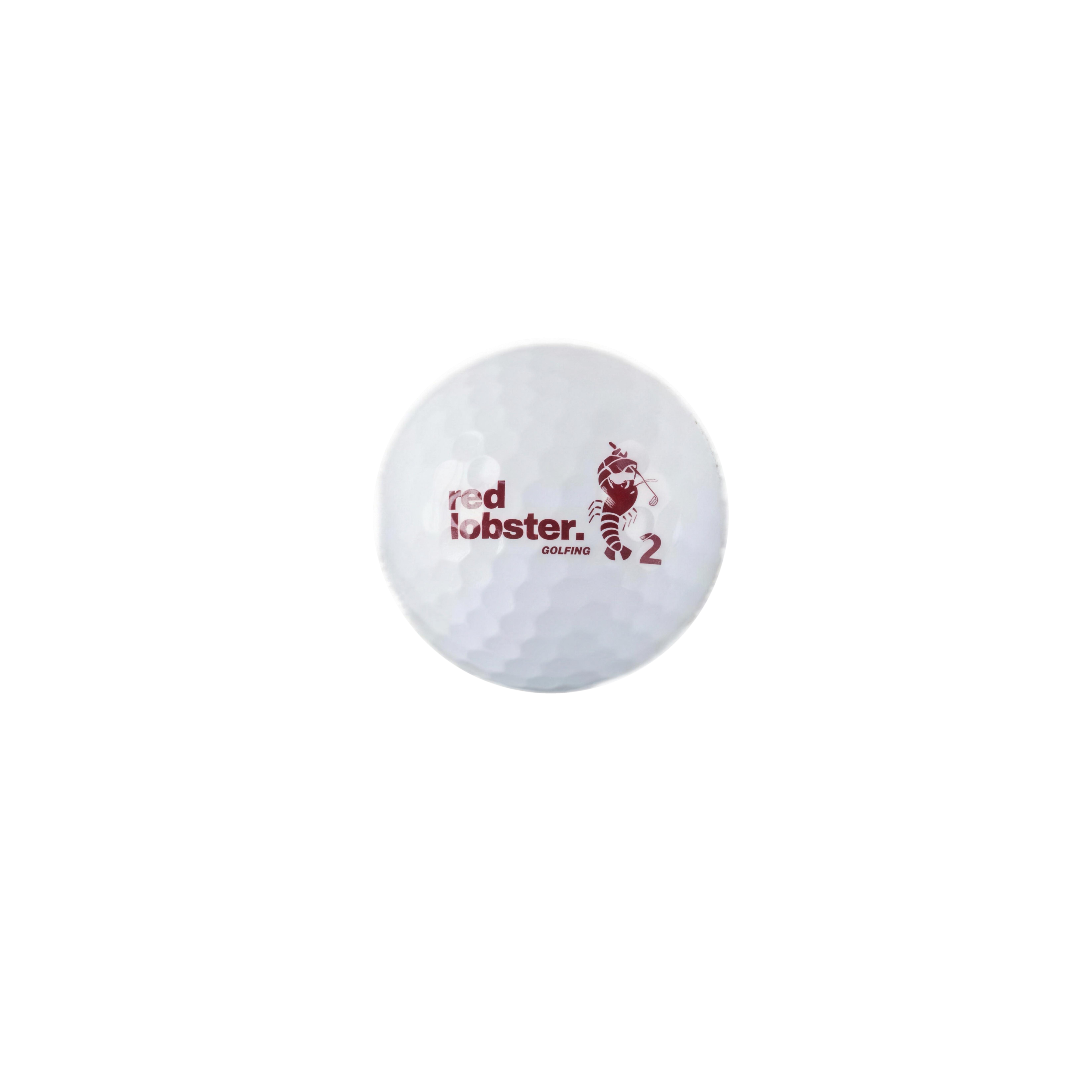 Weißer Lobbie PURE Golfball mit Red Lobster Golfing Logo, Hummer-Motiv und Spielnummer 2 vor weißem Hintergrund